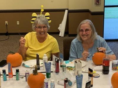 Happy Seniors Painting Pumpkins
